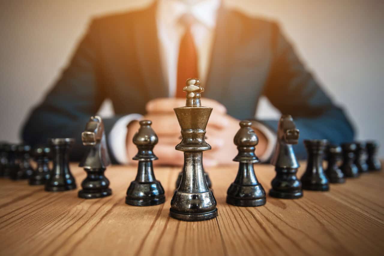 Businessman,Sitting,Behind,Chess,Figure,In,Competition,Success,Play.,Strategy,