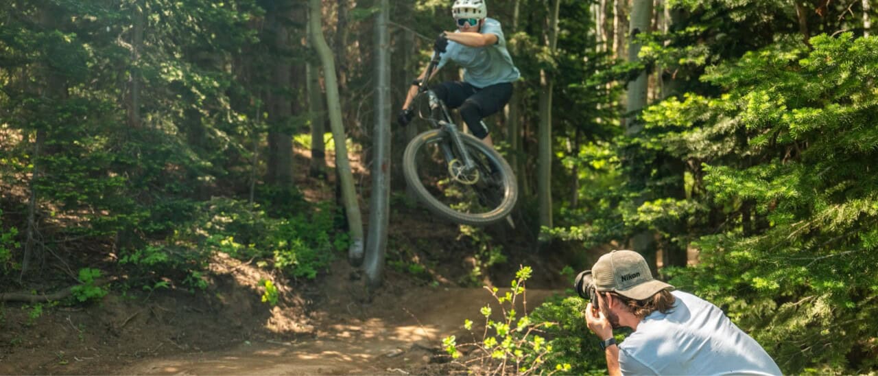 Image of photographer using Nikon camera to capture someone riding their bike outside