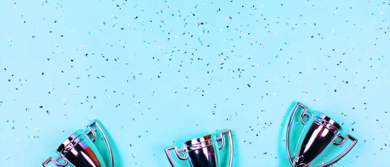 Stock image of silver trophies against a blue background