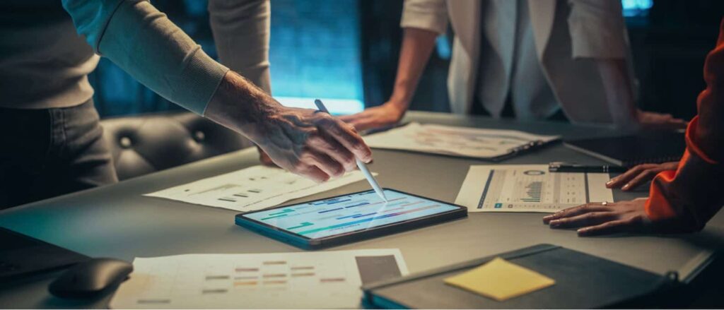 Stock image of people using a tablet during a meeting