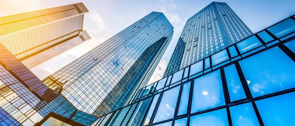 Tall glass skyscrapers reflecting the sky in a financial district.