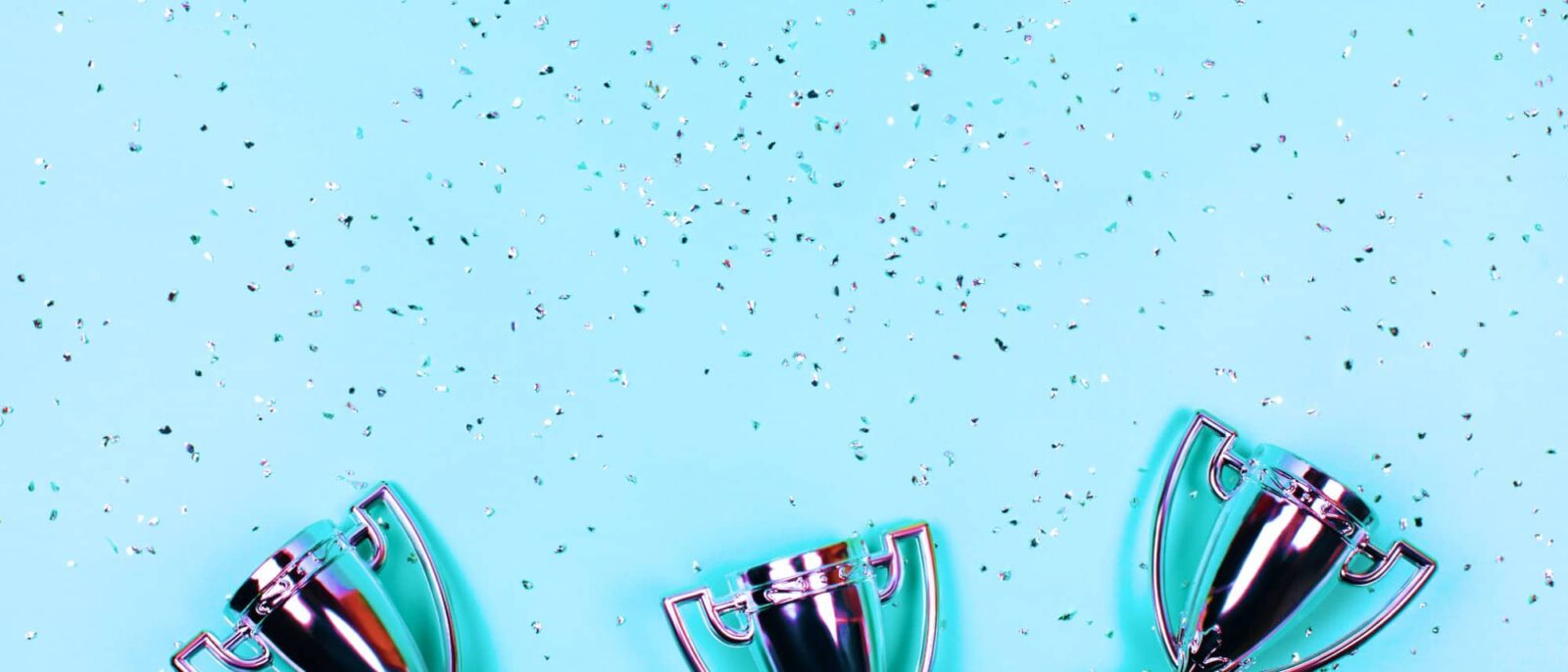 Stock image of silver trophies against a blue background